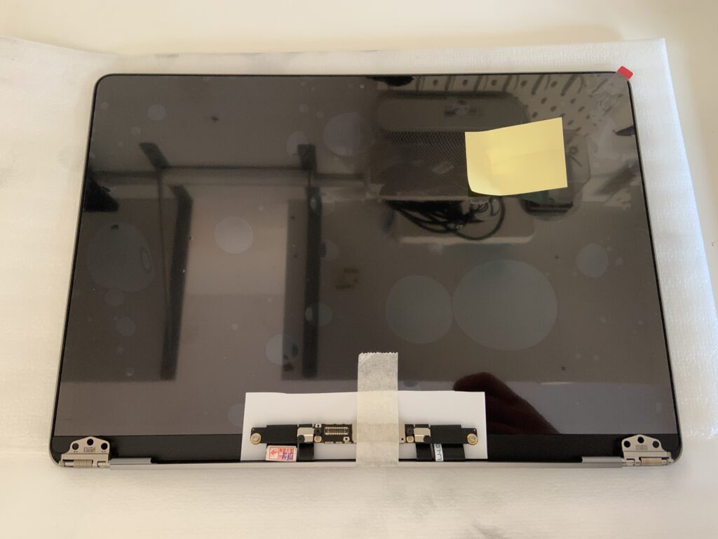 Ricambio display completo nuovo per MacBook Pro A1706 in primo piano sul banco di lavoro