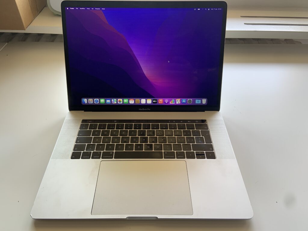 MacBook Pro A1990 Silver acceso con righine orizzontali visibili su tutto lo schermo, ritirato a domicilio a Quartino.