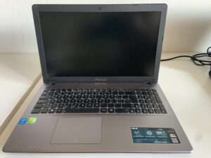 ASUS K550J aperto sul banco per la sostituzione del trackpad, riparazione per un cliente di Cugnasco