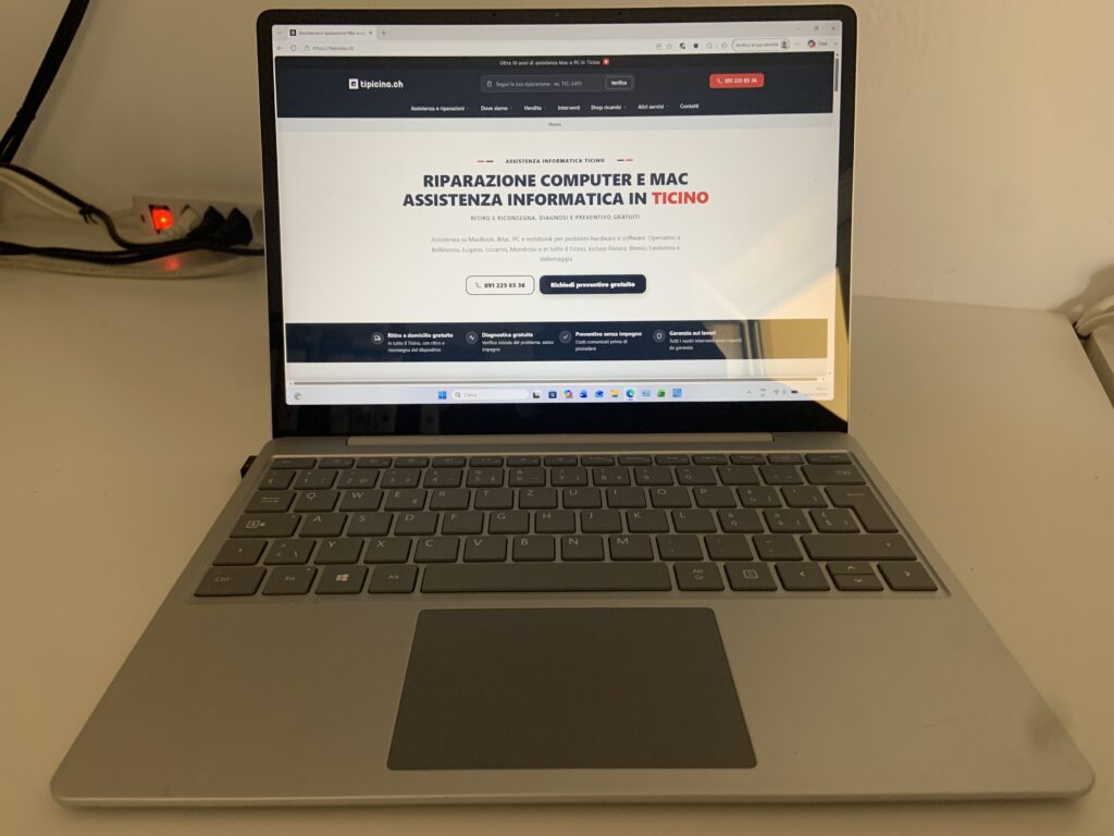 Microsoft Surface Laptop Go acceso con Windows reinstallato e il sito tipicino.ch a schermo, riparazione da Castione