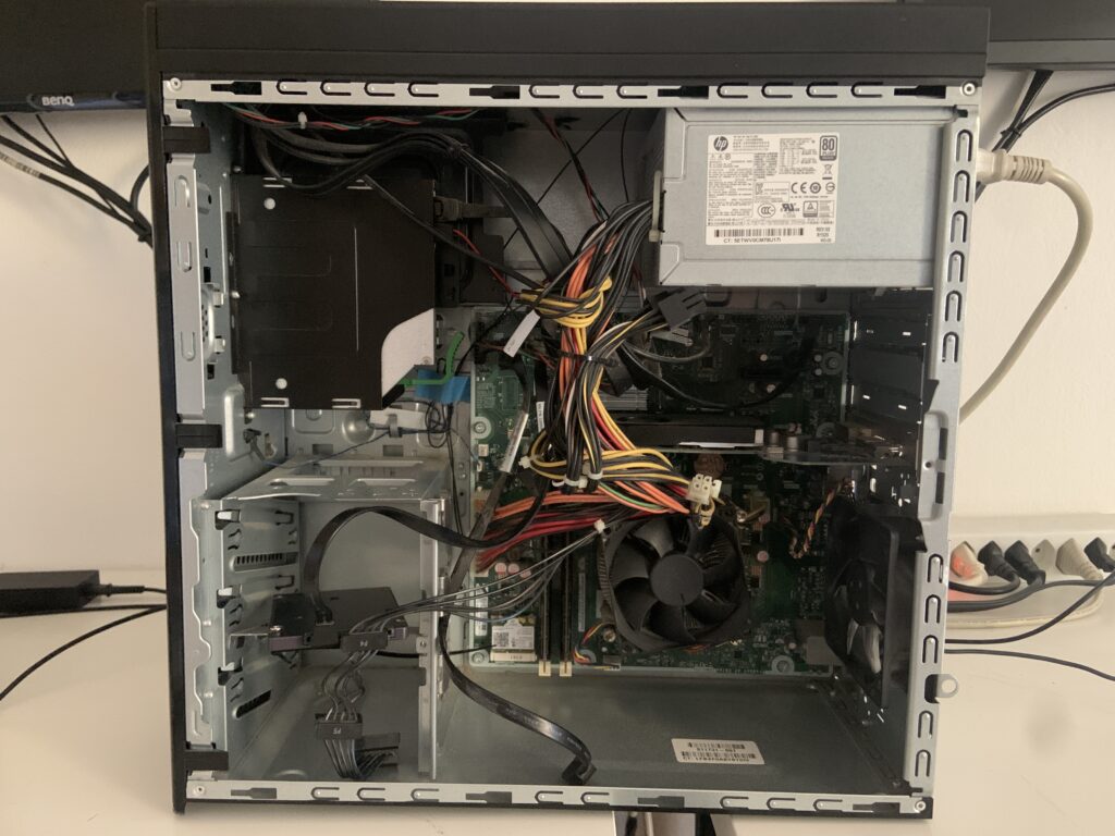 PC desktop HP aperto sul banco durante la sostituzione del disco rotto con un SSD, per un cliente di Gudo